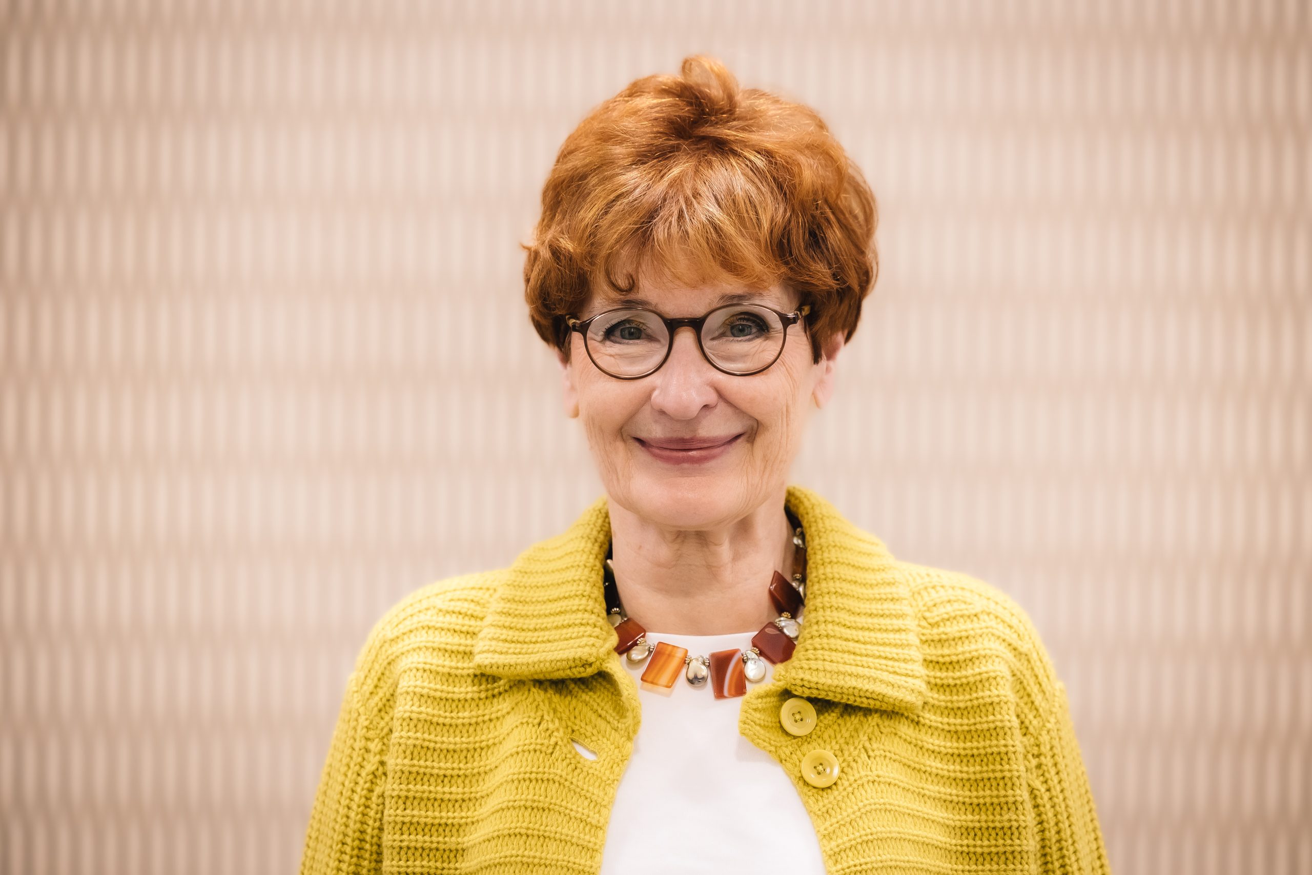 Porträt einer Frau mit einer gelben Strickjacke